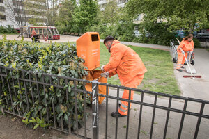 BSR-Reiniger leert Abfalleimer auf einem Spielplatz