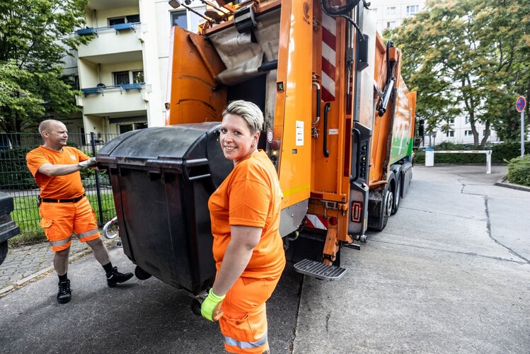 BSR-Beschäftigte mit Müllcontainer an der Schüttung eines Müllfahrzeugs_© BSR_Amin Akhtar