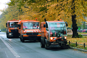Kolonne von BSR-Reinigungsfahrzeugen im Herbst.