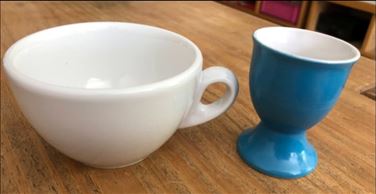 Abbildung: Weiße Tasse + blauer Eierbecher