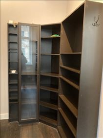 Abbildung: Dunkles Regalsystem, Vitrinenschränke mit Malm- Kommode