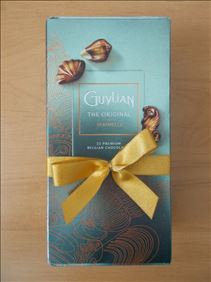 Abbildung: 250g-Packung GUYLIAN-Nougat-Meeresfrüchte gegen 1x CARO